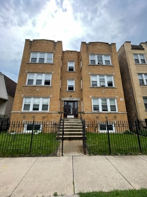 a front view of a residential apartment building with a yard