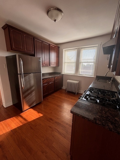 5521 West Farragut Avenue, Unit 3E Chicago, IL 60630 - Photo 3 of 12 a kitchen with stainless steel appliances granite countertop a refrigerator a sink dishwasher a stove and white countertops with wooden floor