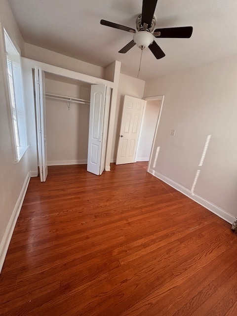 5521 West Farragut Avenue, Unit 3E Chicago, IL 60630 - Photo 7 of 12 an empty room with wooden floor fan and windows