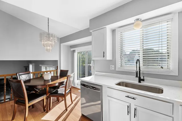 a kitchen with a dining table chairs and large window