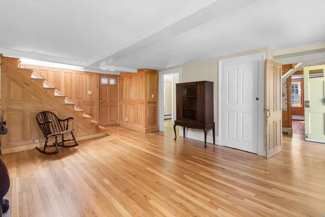 a view of a livingroom with wooden floor and furniture