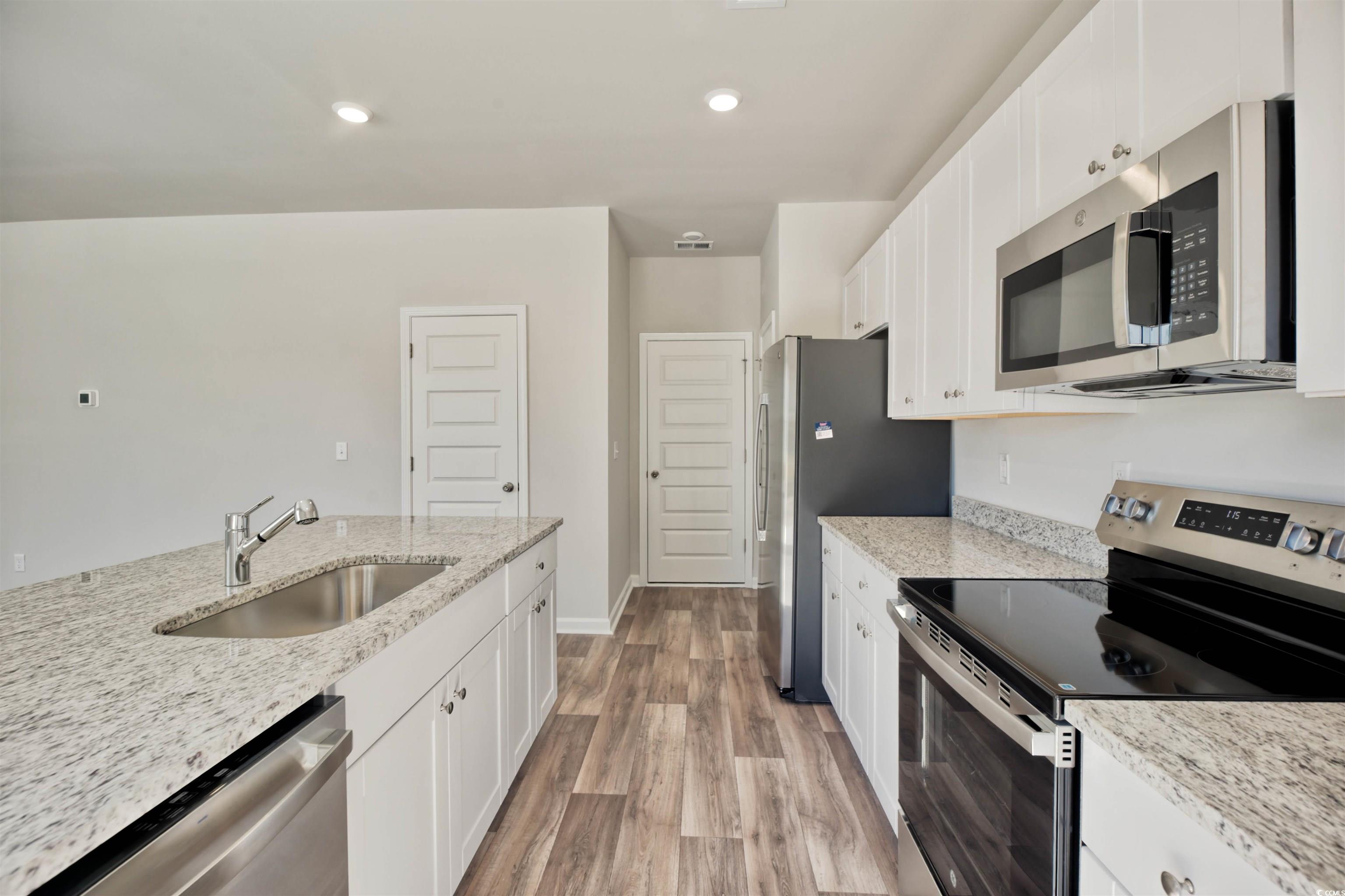 736 Sturdy Root Place Myrtle Beach, SC 29588 - Photo 13 of 15 Kitchen featuring appliances with stainless steel finishes, white cabinetry, light stone countertops, and recessed lighting