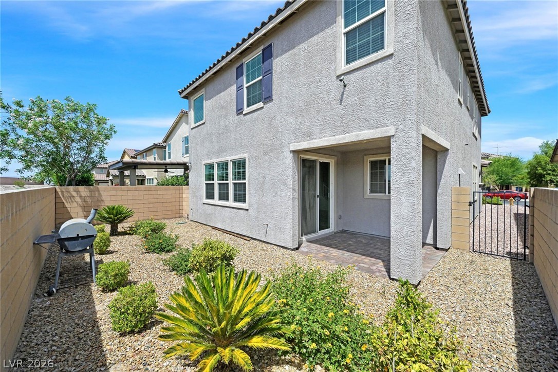 155 Fulgora Street Henderson, NV 89074 - Photo 22 of 30 A spacious backyard with desert landscaping and a paved patio, perfect for outdoor entertaining.