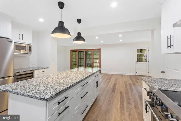 a kitchen with granite countertop sink and refrigerator