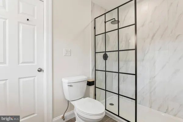 a white toilet sitting next to a shower
