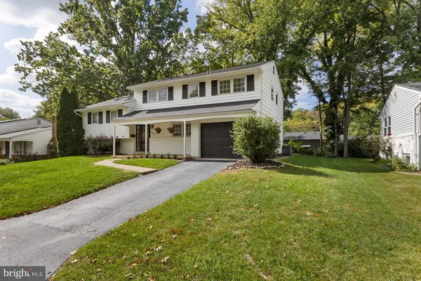 a front view of a house with a yard and trees