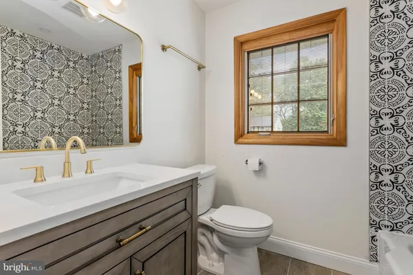 a bathroom with a sink a toilet and a window