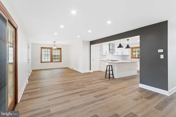 a view of an empty room with wooden floor and windows