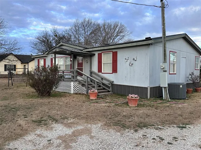 a view of a house with a yard and a tree