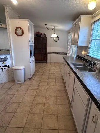 a kitchen with granite countertop a stove a sink and a refrigerator
