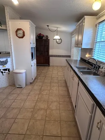 a kitchen with granite countertop a stove a sink and a refrigerator