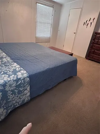 a bed sitting in a bedroom next to a window