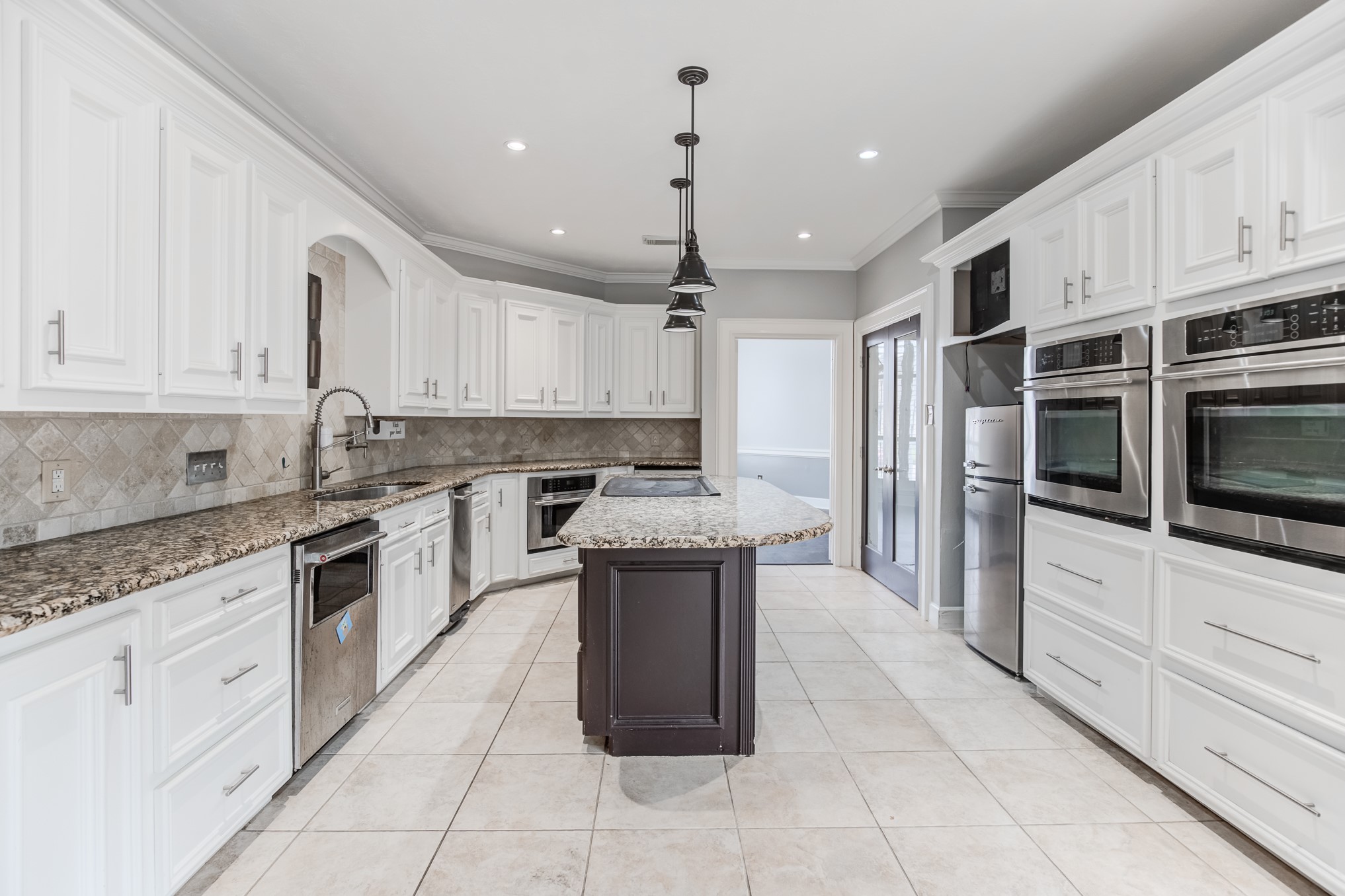11618 Snowmass Drive Houston, TX 77070 - Photo 17 of 36 a kitchen with kitchen island granite countertop a stove sink and cabinets