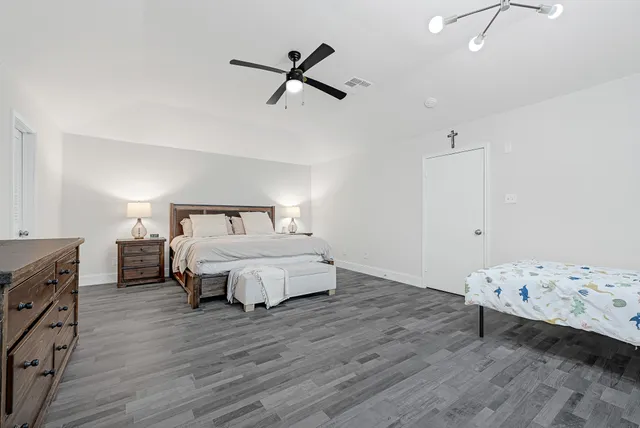 a bedroom with a bed and wooden floor