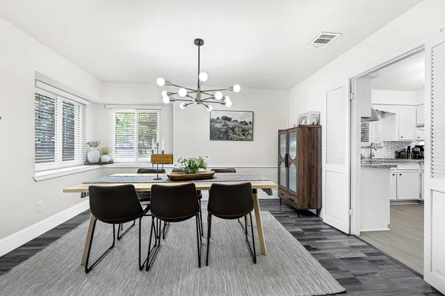 a view of a dining room with furniture a chandelier and wooden floor