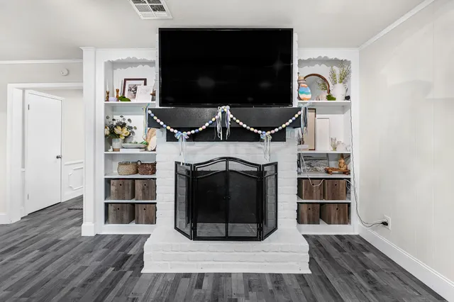 a living room with a fireplace and a flat screen tv
