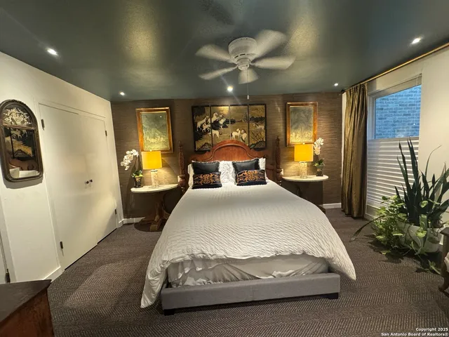 a spacious bedroom with a bed and a chandelier