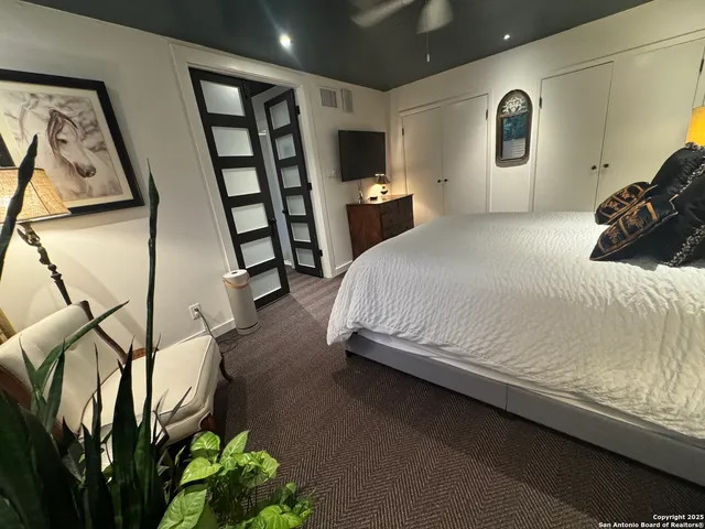 a spacious bedroom with a bed and a flat screen tv