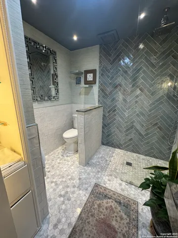 a bathroom with a glass door shower and vanity