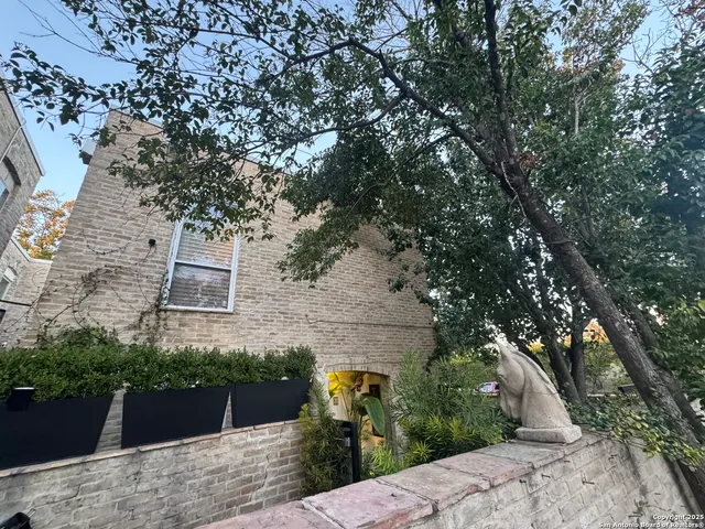 an aerial view of a house with a yard and large tree