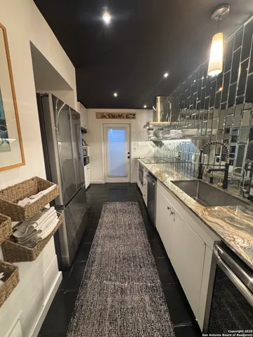 a kitchen with sink stove and refrigerator