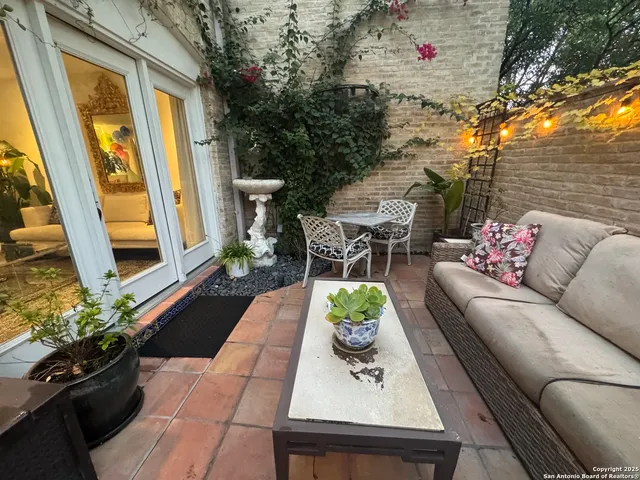 a view of a patio with couches table and chairs and potted plants