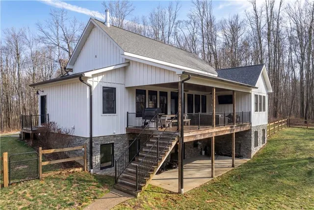 a view of house with large windows and plants