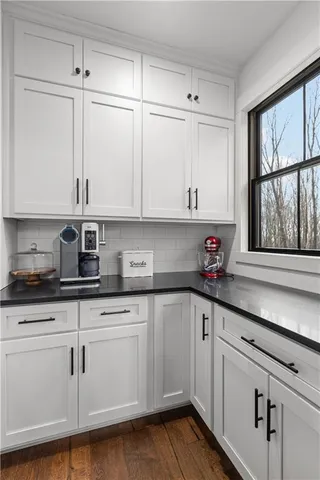 a kitchen with granite countertop white cabinets and white appliances