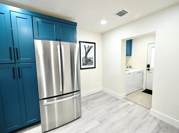 a view of kitchen with wooden floor and electronic appliances