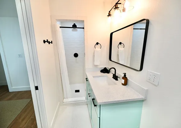 a bathroom with a sink and mirror with toilet
