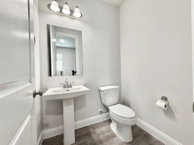 a bathroom with a toilet a sink and mirror