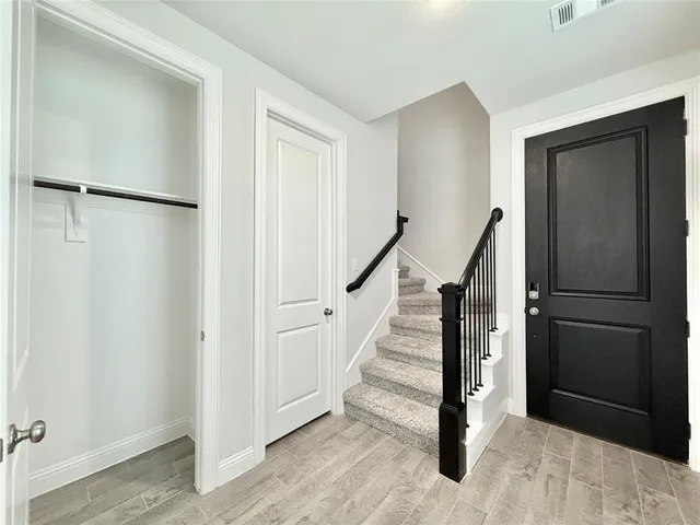 a view of a hallway with wooden floor and entryway