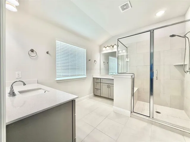 a bathroom with a sink vanity granite tub shower and mirror