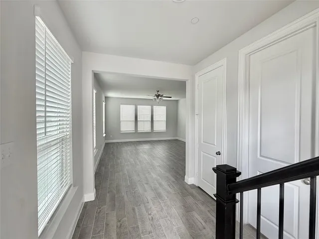 a view of a hallway with wooden floor and stairs