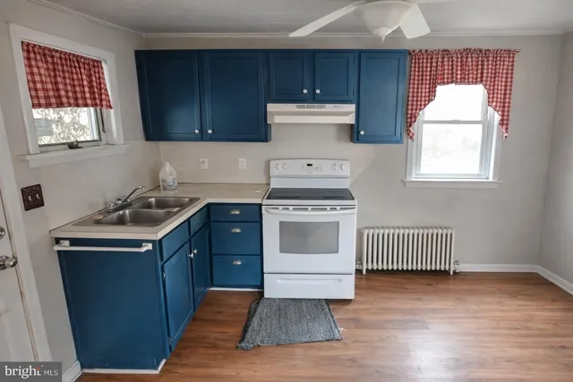 a kitchen with a sink cabinets appliances and a window