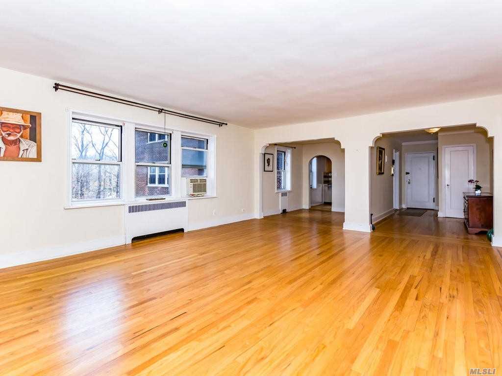 a view of empty room with wooden floor and window