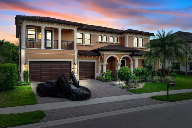 a view of a brick house with a yard and large trees