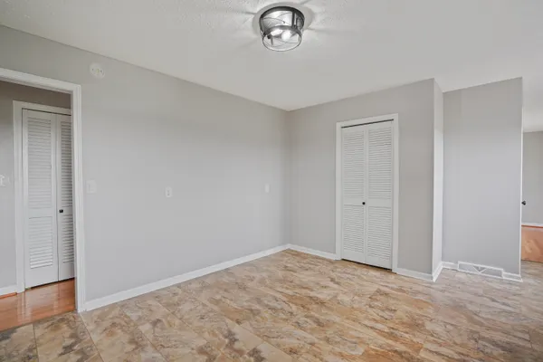 a view of empty room with window and wooden floor
