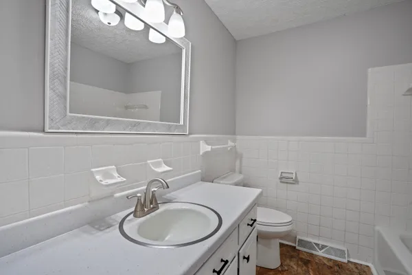 a bathroom with a sink a toilet and a mirror