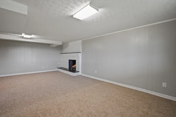 an empty room with a fireplace and a window