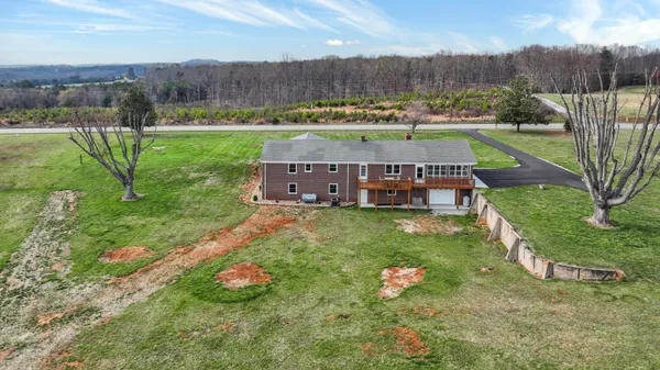an aerial view of a house with pool and a yard