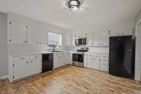 a kitchen with a refrigerator sink and cabinets