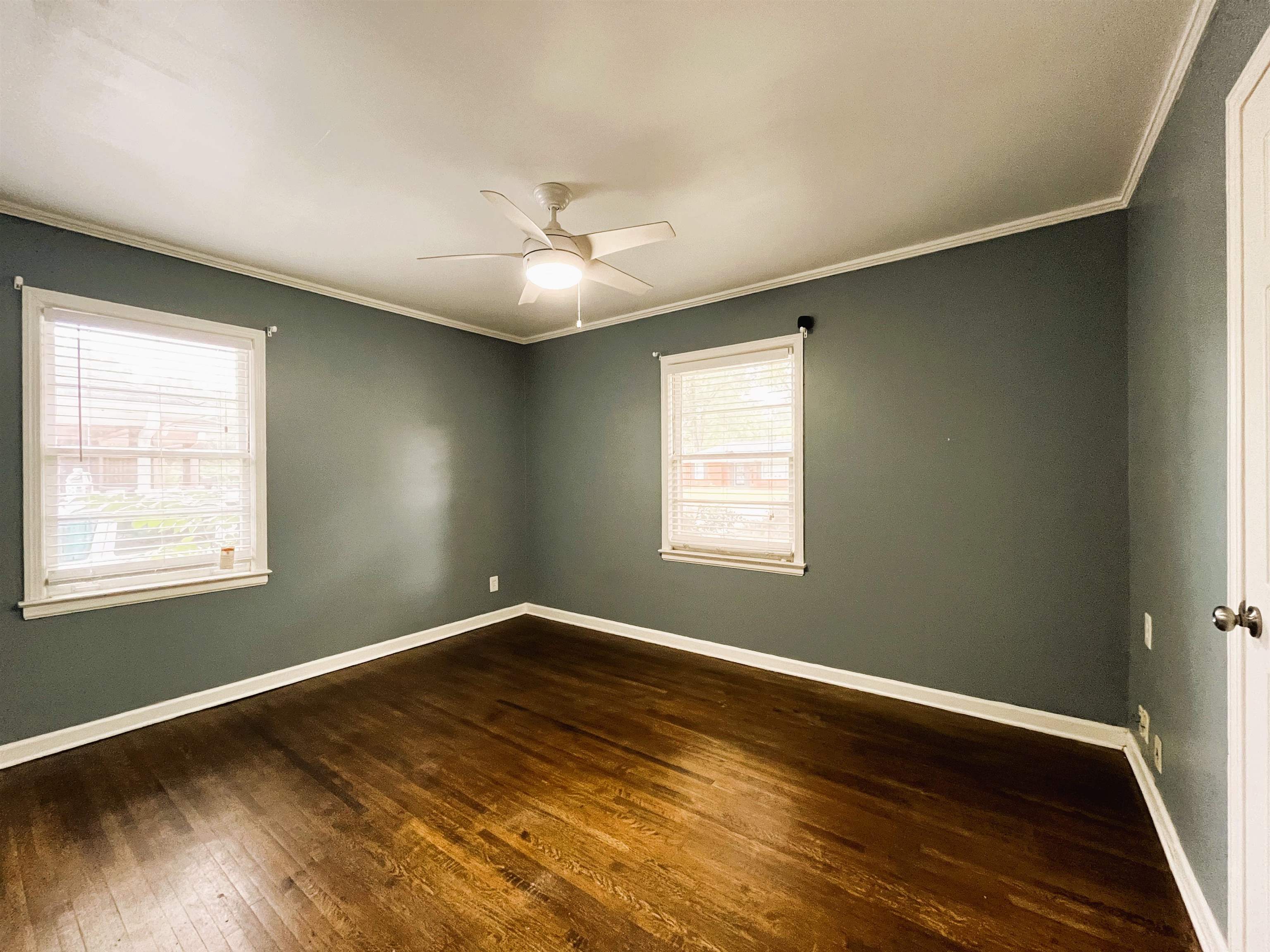 1570 Dearing Road Memphis, TN 38117 - Photo 13 of 16 Empty room with dark wood-style floors, crown molding, and a ceiling fan