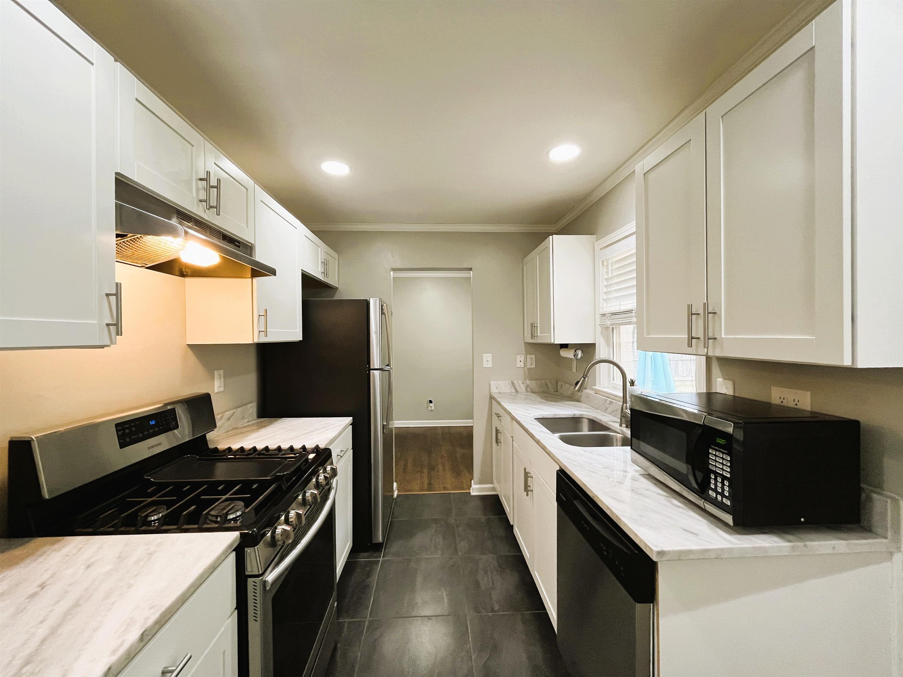 1570 Dearing Road Memphis, TN 38117 - Photo 8 of 16 Kitchen featuring appliances with stainless steel finishes, white cabinets, under cabinet range hood, recessed lighting, and light stone counters