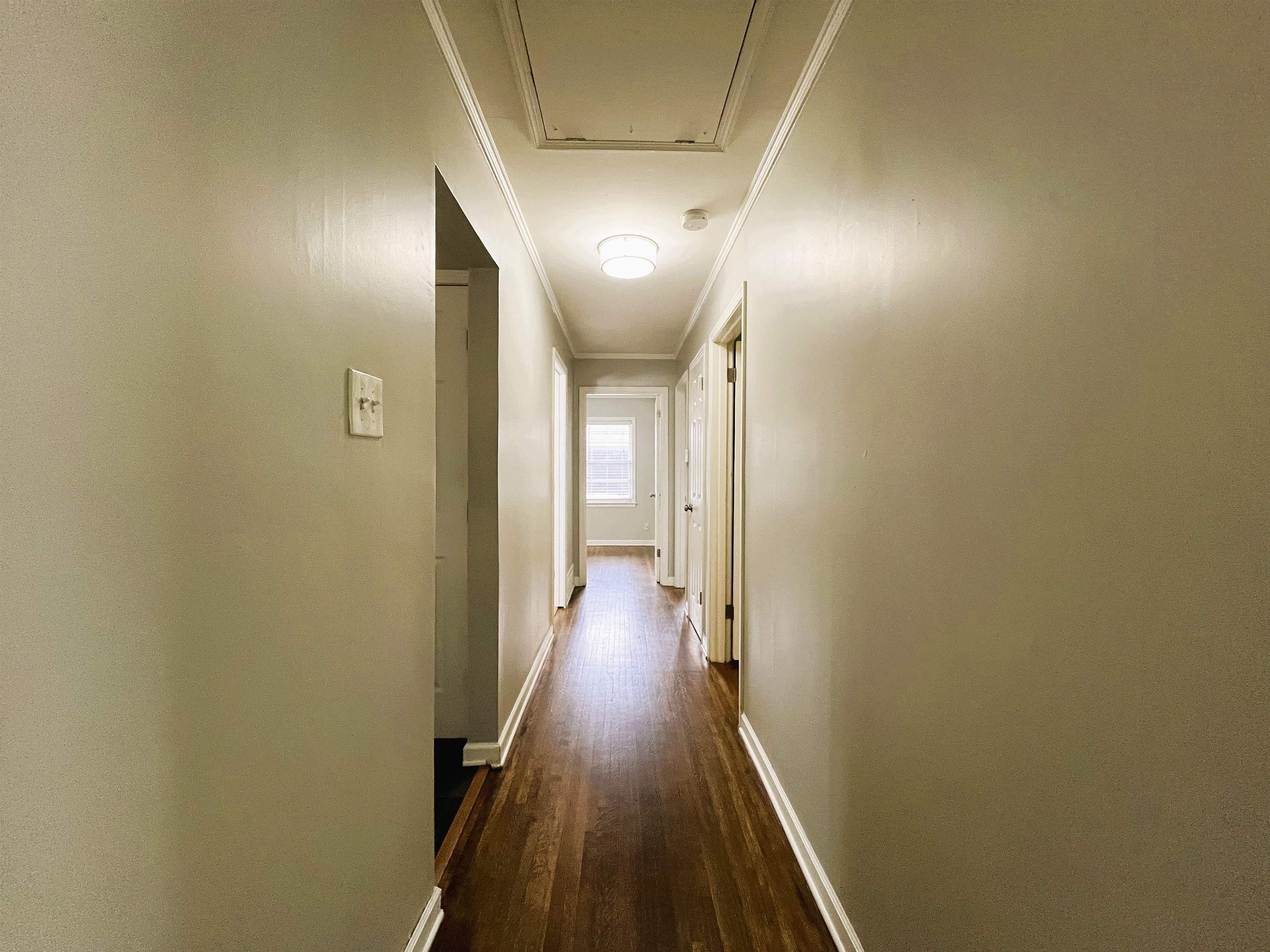 1570 Dearing Road Memphis, TN 38117 - Photo 9 of 16 Corridor with ornamental molding, dark wood finished floors, and attic access