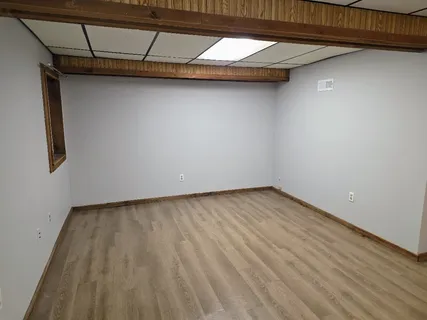 a view of a room with wooden floor and bench