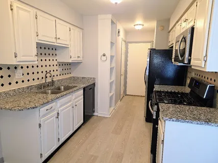 a kitchen with granite countertop a sink stove and refrigerator