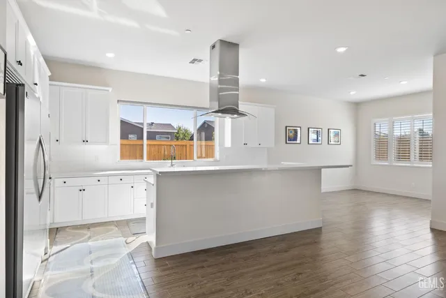 a kitchen with stainless steel appliances granite countertop a sink a stove and a refrigerator