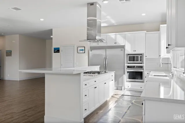 a kitchen with stainless steel appliances a stove refrigerator and cabinets