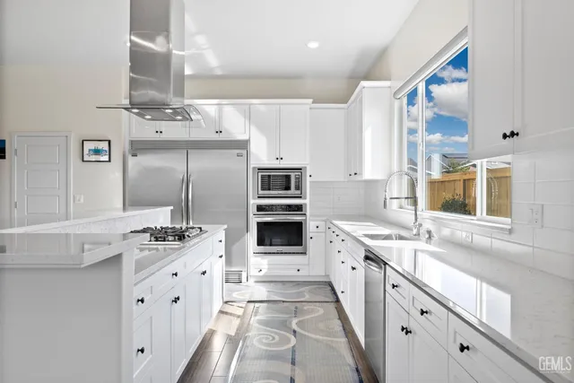 a kitchen with stainless steel appliances kitchen island granite countertop a sink and cabinets